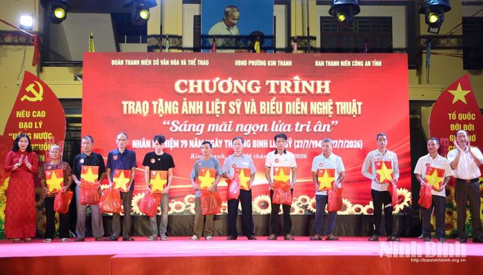 Ban Tổ chức trao tặng ảnh cho thân nhân gia đình liệt sĩ. Ảnh: Nguyễn Oanh