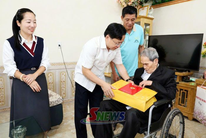 Đồng chí Bí Thư Tỉnh ủy tặng quà thương binh Phan Văn Phụng.