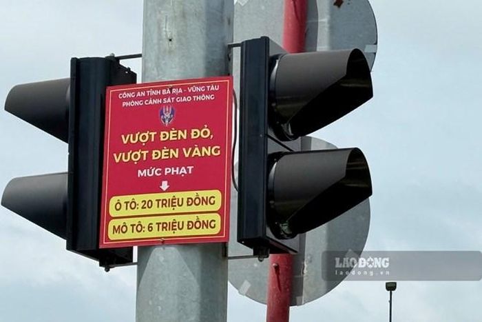 Thông báo về mức phạt khi vượt đèn đỏ được gắn tại một số nút giao ở TPHCM. Ảnh: Thành An