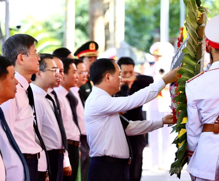 Đồng chí Trịnh Văn Quyết chỉnh vòng hoa kính dâng các Anh hùng liệt sĩ. Ảnh: Duy Tuấn