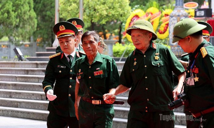 Cựu chiến binh cao tuổi được các lực lượng hỗ trợ khi tới dự buổi lễ. Ảnh: Minh Châu