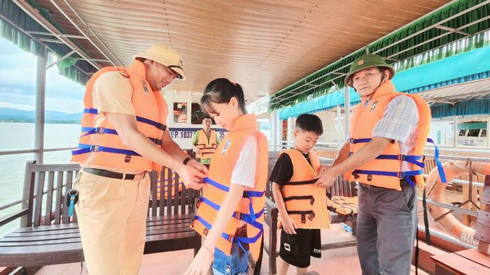 Ông Nguyễn Bằng Quang, cán bộ Trung tâm Dịch vụ sự nghiệp công phường Xuân Hòa và trung tá Ngô Đăng Khoa, Phó đội trưởng Đội Cảnh sát đường thủy số 2 nhắc nhở và hướng dẫn du khách mặc áo phao tại các tàu chở khách.