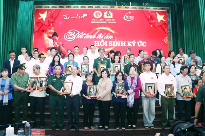Phó Bí thư Thành ủy Văn Thị Bạch Tuyết, Chính ủy Bộ Tư lệnh thành phố, Thiếu tướng Nguyễn Thành Trung, cùng các đại biểu tặng di ảnh đã được phục chế cho thân nhân gia đình liệt sĩ. Ảnh: Hoa Lê