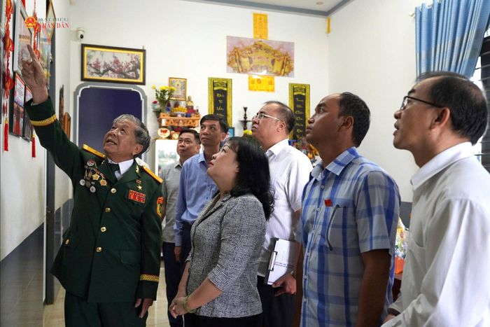 Chủ tịch HĐND tỉnh Cao Thị Hòa An và đoàn công tác lắng nghe Anh hùng Lực lượng vũ trang nhân dân Phạm Huy Nghệ kể lại kỷ niệm năm xưa. Ảnh:L.A