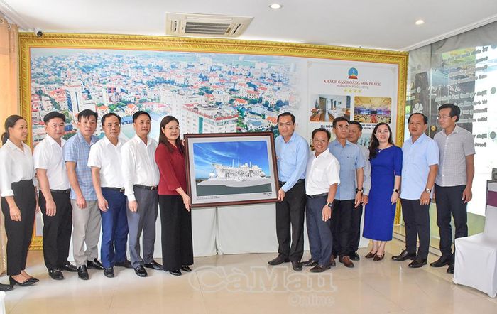 Đồng chí Ngô Vũ Thăng, Phó Chủ tịch UBND tỉnh Cà Mau, trao tặng bức tranh lưu niệm "Tượng đài Chuyến tàu tập kết ra Bắc" đến đồng chí Hà Lan Anh, Phó Chủ tịch UBND tỉnh Ninh Bình, thể hiện tình cảm gắn bó giữa 2 địa phương.