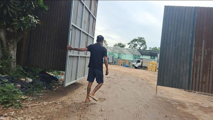  Thấy phóng viên ghi hình khu vực san lấp, nhân viên bãi xe liền vội vàng đóng cổng lại để tránh ghi hình hoạt động bãi xe, vận chuyển hàng hóa bên trong.Ảnh PV. 