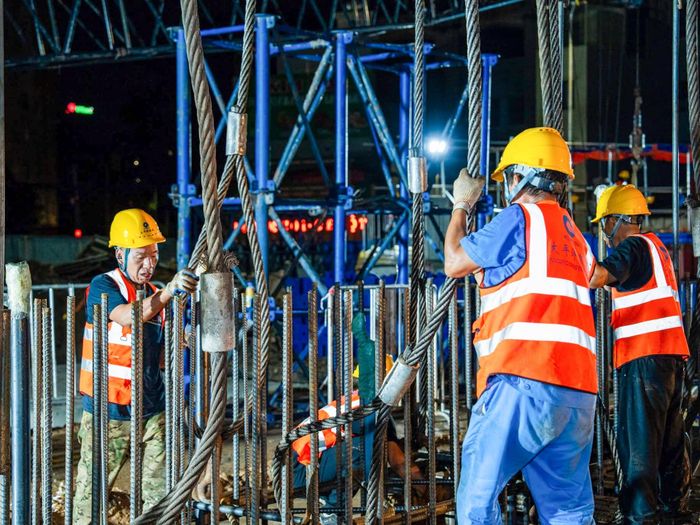 Đây là hạng mục kỹ thuật phức tạp với lồng thép siêu trường siêu trọng dài 42m, nặng hơn 38,5 tấn. Quá trình hạ lồng thép đòi hỏi sự phối hợp đồng bộ giữa 2 cần trục bánh xích sức nâng 500 tấn và 180 tấn để xoay lồng thép từ tư thế nằm ngang sang thẳng đứng trước khi hạ chính xác vào hố đào đã được kiểm tra và làm sạch. Mọi thao tác đều được kiểm soát chặt chẽ nhằm bảo đảm đúng vị trí thiết kế và yêu cầu kỹ thuật. (Ảnh: MRB)