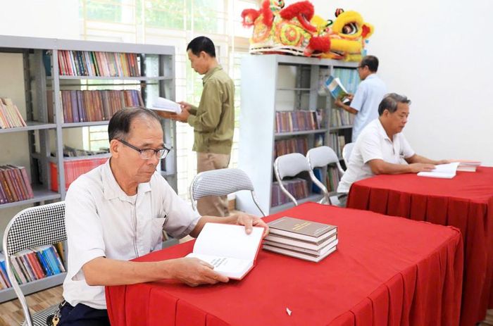 Người dân đọc sách tại thư viện ở Nhà văn hóa thôn Giang Triều (xã Ứng Hòa). Ảnh: Nguyễn Quang