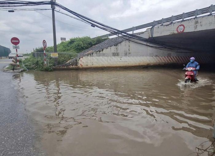 "Mỗi khi mưa lớn, hầm chui trên tuyến đường H10 qua cao tốc Pháp Vân - Cầu Giẽ lại ngập sâu. Đây là tuyến đường có lưu lượng phương tiện lớn nên không ít xe bị chết máy khi đi qua hầm chui hoặc va phải chướng ngại vật chìm dưới nước, dẫn đến ngã xe, rất nguy hiểm", ông Vũ Văn Tám (xã Phú Xuyên) cho biết. Ảnh: PV