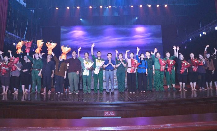 Phó Giám đốc Cơ quan Báo và Phát thanh, Truyền hình Hà Nội Nguyễn Minh Đức và Giám đốc Nhà hát Kịch nói Quân đội Lê Thị Mai Phương tặng hoa các nghệ sĩ thể hiện thành công vở diễn. Ảnh: Phạm Hùng