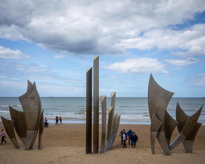 Du khách tham quan tượng đài Les Braves trên bãi biển Omaha ở Normandy. Ảnh: EPA.