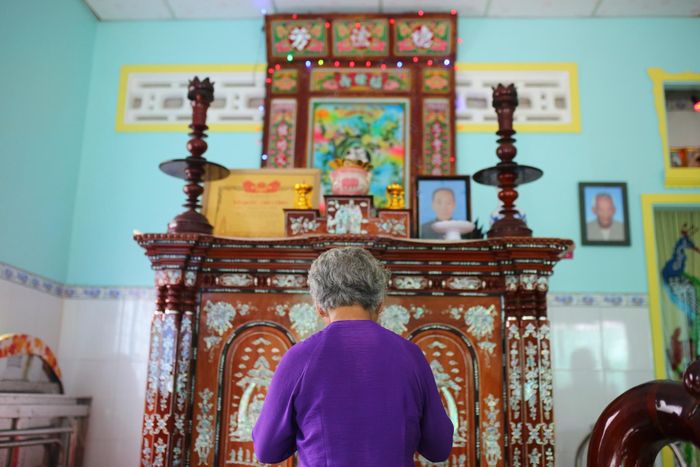  Bà Lệ thắp nén nhang trên bàn thờ gia tiên nhà họ Huỳnh sáng 7/7. Nơi thờ cúng không có di ảnh liệt sĩ Huỳnh Văn Quên, chỉ có Bằng Tổ quốc ghi công được gia đình nâng niu gìn giữ như sự hiện diện của người con đã hy sinh. Ảnh: Quỳnh Danh 