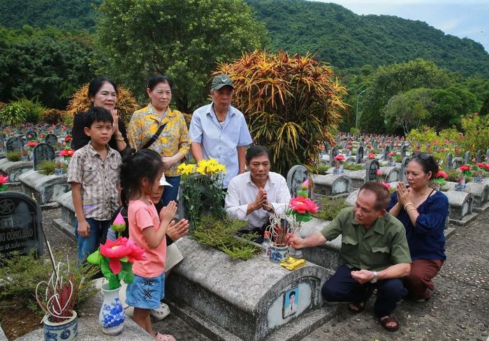Du khách dâng hương, dâng hoa lên mộ các liệt sĩ chưa xác định danh tính tại Nghĩa trang Liệt sĩ quốc tế Đồng Tâm. Ảnh: Trọng Đức - TTXVN