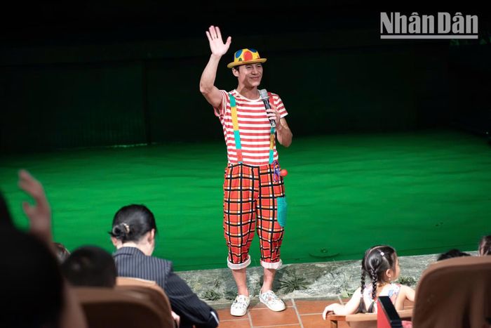 Trong không gian nhà hát, chú hề say sưa giải thích cho các khán giả nhỏ về cách điều khiển con rối.