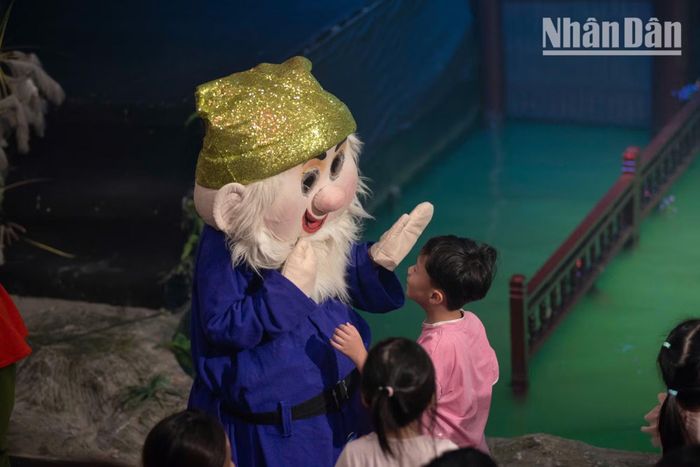 Nàng Bạch Tuyết và bảy chú lùn bước ra khỏi sân khấu để chụp ảnh lưu niệm cùng khán giả nhí. Những cái ôm, những cái bắt tay thân thiện khiến thế giới thần tiên trở nên thật hơn bao giờ hết.