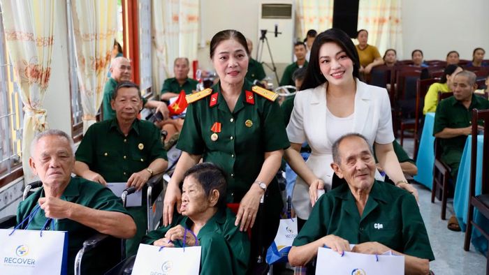 Bà Nguyễn Thiên Linh (áo trắng) đại diện Trung tâm Chăm sóc sức khỏe và phục hồi chức năng Recover trao quà tri ân các thương bệnh binh.