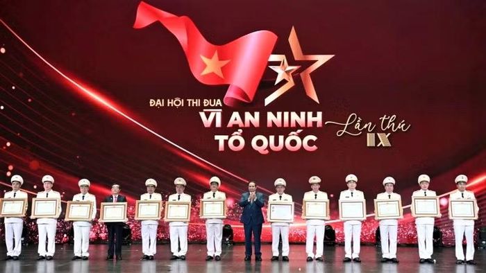 Thượng tá Bùi Quang Vinh (thứ 4 từ trái sang) đón nhận danh hiệu Anh hùng Lực lượng vũ trang nhân dân của cha mình - liệt sĩ Bùi Huy Giáp (Ảnh: V. Quang).