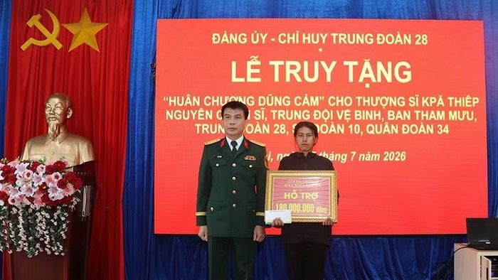 Đại tá Hồ Sỹ Chiến, Chính ủy Sư đoàn 10, Quân đoàn 34 trao quà cho gia đình Thượng sĩ Kpă Thiêp.