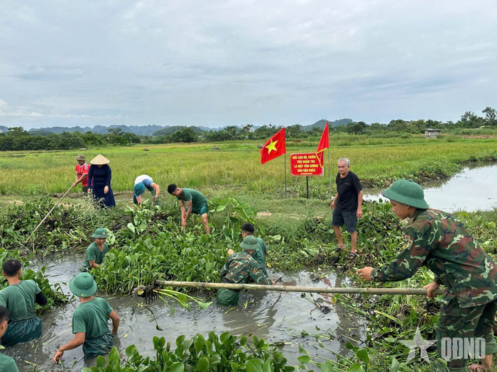 Cán bộ, chiến sĩ Tiểu đoàn 703 giúp nhân dân phường Quang Trung (tỉnh Thanh Hóa) nạo vét kênh mương, khơi thông dòng chảy.
