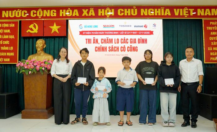  Đại diện Báo SGGP và chính quyền địa phương tặng học bổng do Quỹ Tâm Tài Việt tài trợ cho học sinh con em gia đình chính sách vượt khó học tốt của xã. Ảnh: VIỆT NGA 