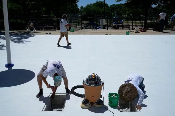 Một nhóm công nhân làm công việc sửa chữa tại công viên Bryant Square ở Minneapolis giữa trời nắng nóng ngày 13/7/2026. Ảnh: AP/Ellen Schmidt.
