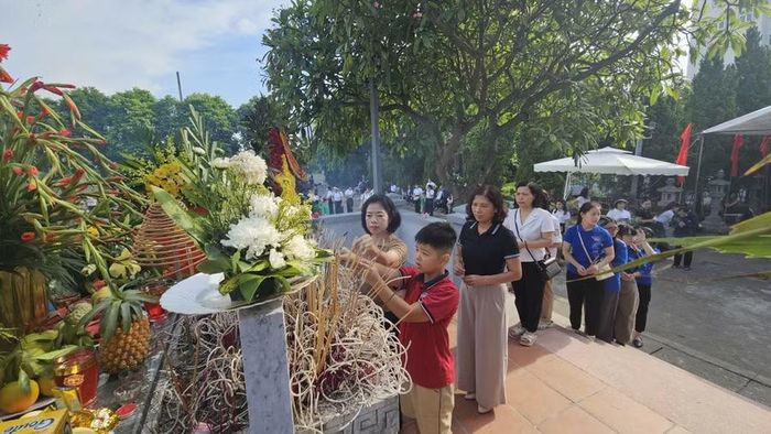 Đại diện học sinh và thầy cô giáo thắp hương tri ân các anh hùng liệt sĩ tại Nghĩa trang liệt sĩ xã An Khánh, Hà Nội sáng 27/7.