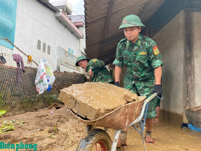 Cán bộ, chiến sĩ Bộ đội Biên phòng hỗ trợ nhân dân vệ sinh nhà cửa sau thiên tai. Ảnh: Văn Hợi
