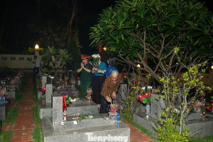 Sau khi thắp hương cho người lính tuổi 20, Mẹ Ngỏ đi thắp hương phần mộ của các liệt sĩ xung quanh con trai mình.