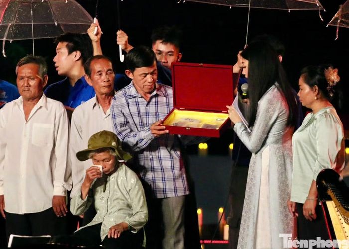 Gia đình liệt sĩ Huỳnh Văn Quên nhận lại di vật. (Ảnh: Ngô Tùng)