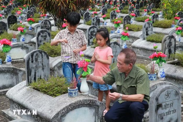 Dâng hương lên phần mộ liệt sỹ tại Nghĩa trang Liệt sỹ Quốc tế Đồng Tâm. (Ảnh: Trọng Đức/TTXVN)