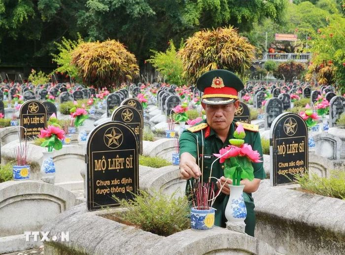 Dâng hương lên những phần mộ liệt sỹ chưa xác định thông tin tại Nghĩa trang Liệt sỹ Quốc tế Đồng Tâm. (Ảnh: Trọng Đức/TTXVN)