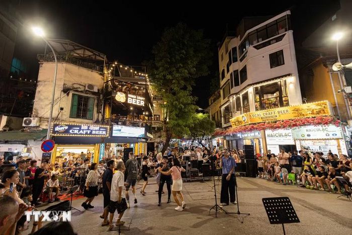 Biểu diễn âm nhạc đường phố sôi động, hiện đại tại khu vực giao lộ Phố cổ Hà Nội. Các đêm nhạc ngẫu hứng cuối tuần không chỉ làm phong phú thêm sản phẩm du lịch đêm mà còn tạo điểm nhấn không gian văn hóa mở, thu hút du khách trong và ngoài nước hòa mình vào nhịp sống trẻ trung của Thủ đô. (Ảnh: Tiến Long/TTXVN phát)