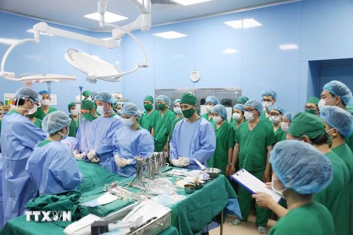 Đội ngũ y bác sỹ Bệnh viện Bãi Cháy và các chuyên gia tuyến Trung ương cúi đầu dành phút mặc niệm tri ân nghĩa cử cao đẹp của người hiến tạng 19 tuổi và gia đình tại Quảng Ninh trước giờ phẫu thuật. (Ảnh: TTXVN phát)