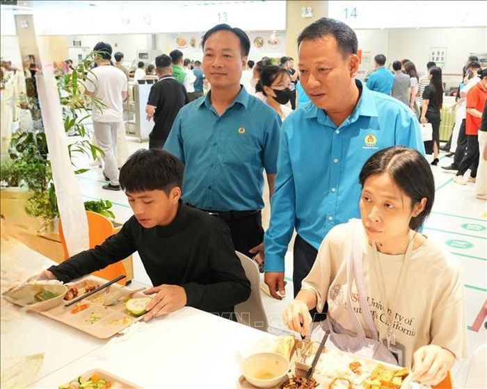 Anh Phạm Văn Trung (bên phải) cùng cán bộ Liên đoàn Lao động tỉnh Bắc Ninh nắm bắt ý kiến công nhân về chất lượng bữa ăn ca tại công ty. Ảnh: Đồng Thúy/TTXVN