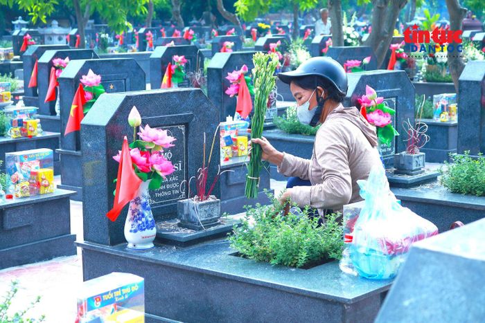 Những bó hoa tươi, nén hương thơm được người dân kính cẩn đặt trước từng phần mộ liệt sĩ.