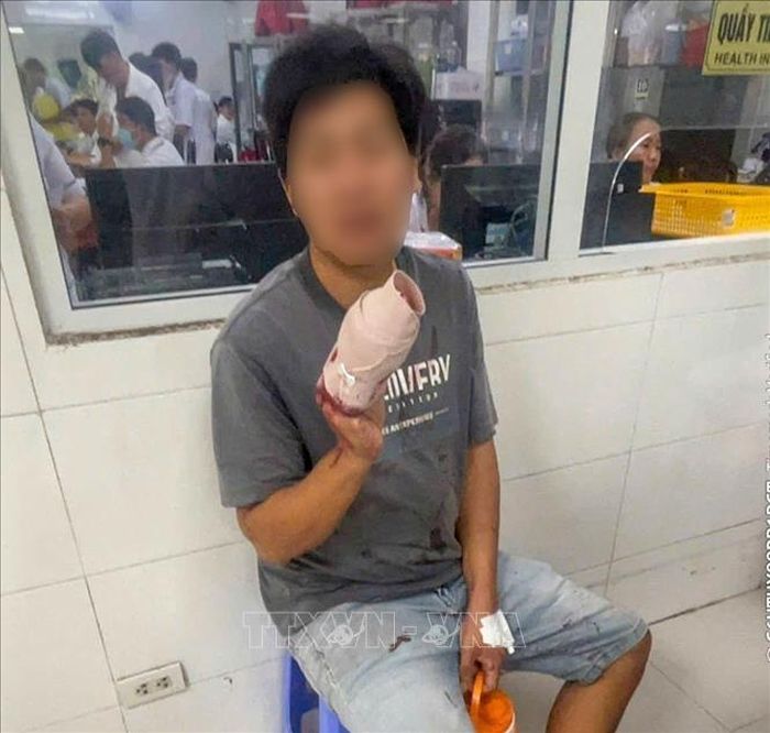 Anh Lâm Thanh Nhân bị tai nạn lao động đứt 4 ngón tay phải được Tổ công tác Trạm Cảnh sát giao thông Mỹ Xuyên hỗ trợ dẫn đường đến cấp cứu tại Bệnh viện Đa khoa Trung ương Cần Thơ. Ảnh: TTXVN phát