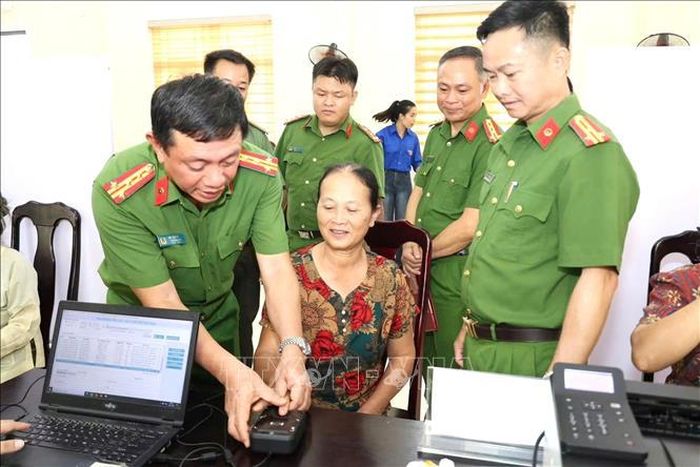 Đại tá Đỗ Tiến Dũng, Phó Giám đốc Công an tỉnh Tuyên Quang trực tiếp hướng dẫn, hỗ trợ thân nhân liệt sĩ thực hiện quy trình thu nhận mẫu sinh phẩm ADN. Ảnh: TTXVN phát