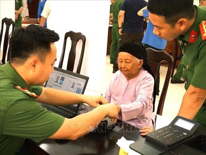 Cán bộ Công an tỉnh Tuyên Quang hướng dẫn thân nhân liệt sĩ hoàn thiện thông tin phục vụ thu nhận mẫu sinh phẩm ADN. Ảnh: TTXVN phát