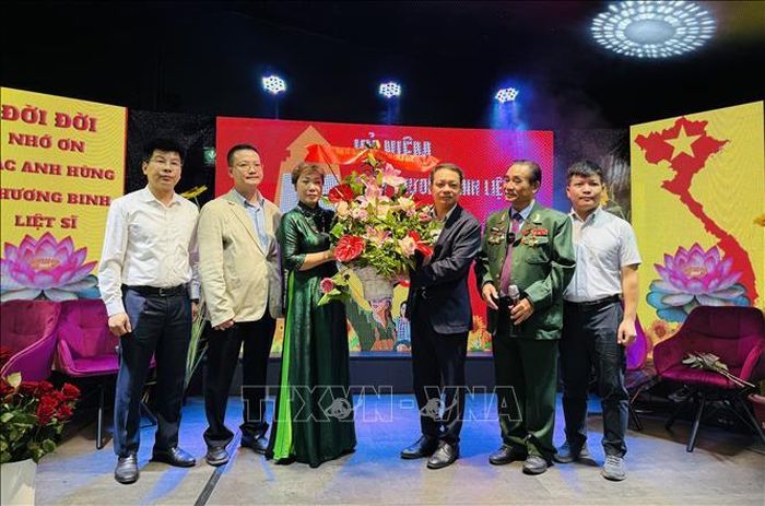 Đại diện Đại sứ quán Việt Nam tại Đức tặng hoa Ban tổ chức chương trình "Tổ quốc ghi công". Ảnh: Thùy Linh/Pv TTXVN tại Đức