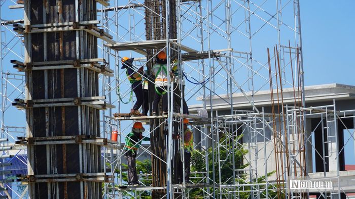 Nhiều tổ công nhân được bố trí tại các vị trí cột, vách và sàn để thực hiện công tác buộc thép, lắp dựng cốp pha và chuẩn bị đổ bê tông. Công nhân đều được trang bị mũ bảo hộ, dây an toàn khi làm việc trên giàn giáo.