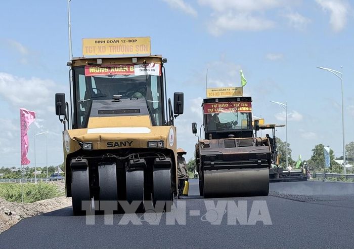 Xe thảm nhựa và các phương tiện thi công hoạt động liên tục trên đường dẫn vào tuyến cao tốc Châu Đốc - Cần Thơ - Sóc Trăng đoạn qua phường Vĩnh Tế, An Giang. Ảnh: Thanh Sang - TTXVN