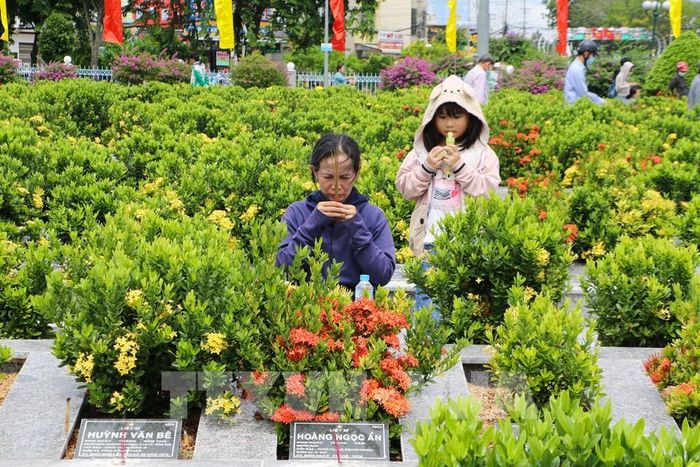Thân nhân đến viếng mộ liệt sĩ. Ảnh: Hồng Thái - TTXVN