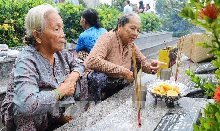 Thân nhân thắp hương tưởng niệm các liệt sĩ. Ảnh: Hồng Thái - TTXVN