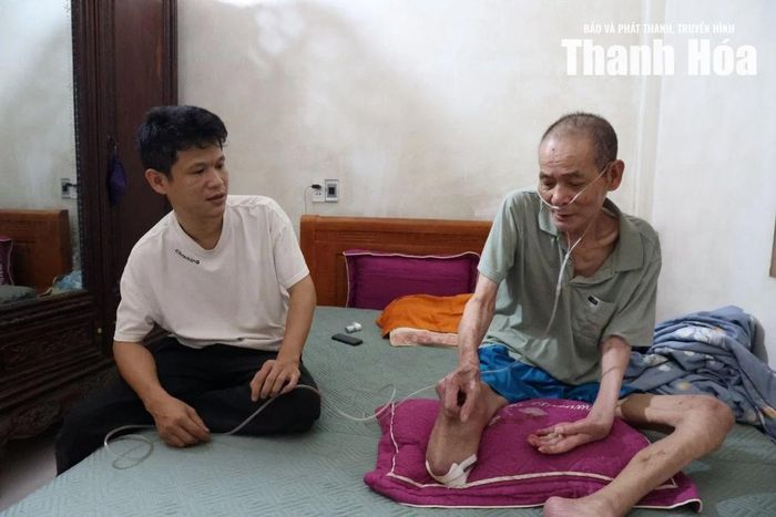 Cựu chiến binh, cựu tù binh Phú Quốc Nguyễn Văn Tự trò chuyện cùng con trai trong căn phòng nơi ông phải thường xuyên sử dụng oxy hỗ trợ hô hấp.