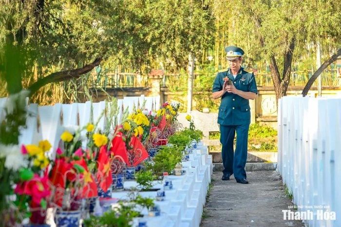 Một cựu chiến binh khoác trên mình bộ quân phục chỉn chu, chậm rãi bước giữa hai hàng mộ trắng. Ảnh: Hoàng Đông