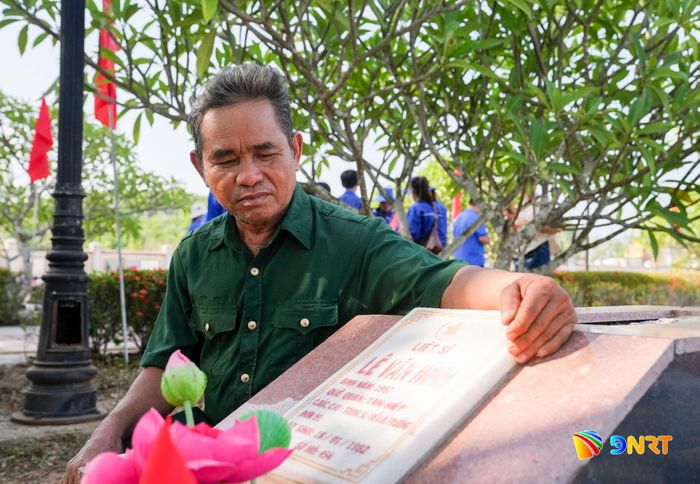 Ông Bùi Thống thăm phần mộ liệt sĩ Lê Văn Minh tại Nghĩa trang liệt sĩ Tam Hiệp (xã Núi Thành) - liệt sĩ được ông hỗ trợ đưa về quê an táng năm 2017 theo nguyện vọng của gia đình. Ảnh: HỒ QUÂN
