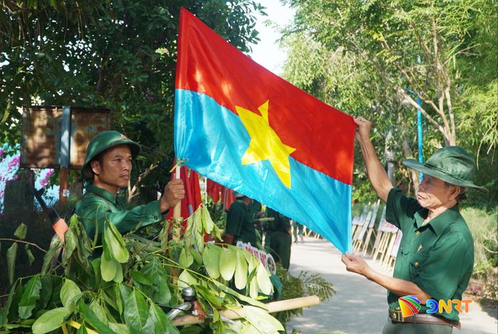 Các cựu binh chỉnh trang lại cờ giải phóng chuẩn bị cho chương trình "Bộ đội về làng". Ảnh: PHAN VINH