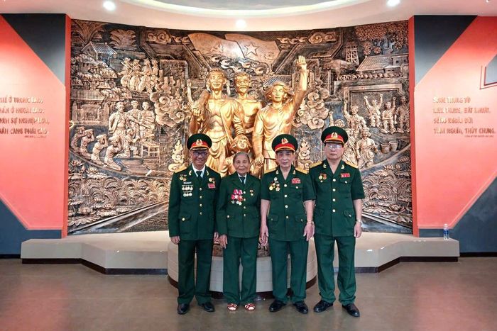Anh hùng Lực lượng vũ trang nhân dân Đặng Thị Én cùng đồng đội trở lại nhà lao Hội An, nơi bà từng bị địch giam giữ, tra tấn. Ảnh: THÚY HIỀN