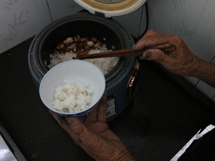 Nồi cơm xới hạt mít thơm lừng nhưng chỉ một đôi đũa, một chén cơm, một mình bà Thu thui thủi ngồi ăn. Ảnh: THÚY HIỀN