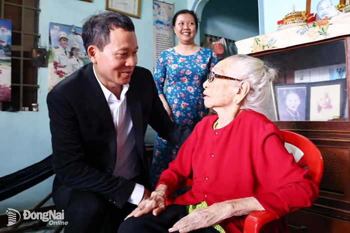 Đồng chí Vũ Hồng Văn, Ủy viên Trung ương Đảng, Bí thư Thành ủy, Trưởng đoàn Đại biểu Quốc hội thành phố ân cần thăm hỏi sức khỏe Mẹ Việt Nam anh hùng Lê Thị Thí. Ảnh: Công Nghĩa